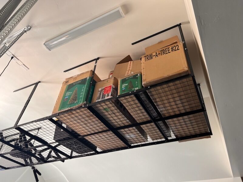 Overhead garage storage rack installed and loaded with holiday storage boxes in a St. George home
